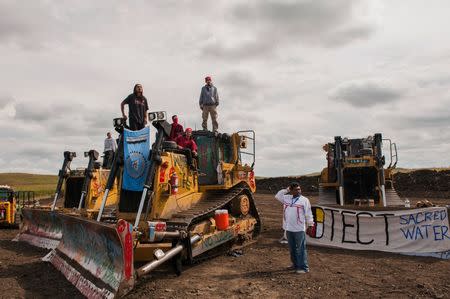 Protesters stand on heavy machinery after halting work on the Energy Transfer Partners Dakota Access oil pipeline near the Standing Rock Sioux reservation near Cannon Ball, North Dakota, September 6, 2016. REUTERS/Andrew Cullen