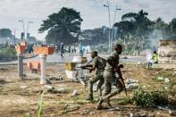 Gabonese soldiers take position as supporters of opposition leader Jean Ping protest in front of security forces blocking a demonstration trying to reach the electoral commission in Libreville