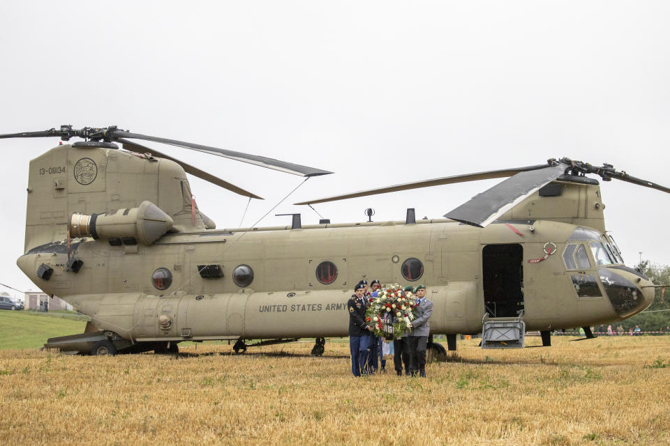 U.S. and German soldiers carry a wreath from a Chinook transport helicopter during a commemoration of a helicopter crash in Pegnitz, Germany, Wednesday, Aug. 18, 2021. On Aug. 18, 1971, a U.S. Army Chinook helicopter crashed near Pegnitz. 37 soldiers were killed. It is the worst accident of the US Army since the Second World War. (Daniel Karmann/dpa via AP)