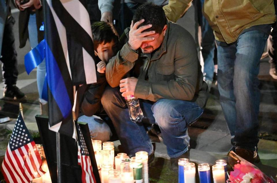 An unidentified man weeps at a memorial at the corner of Veterans Park for slain Selma officer Gonzalo Carrasco Jr. Thursday, Feb 2, 2023 in downtown Selma.