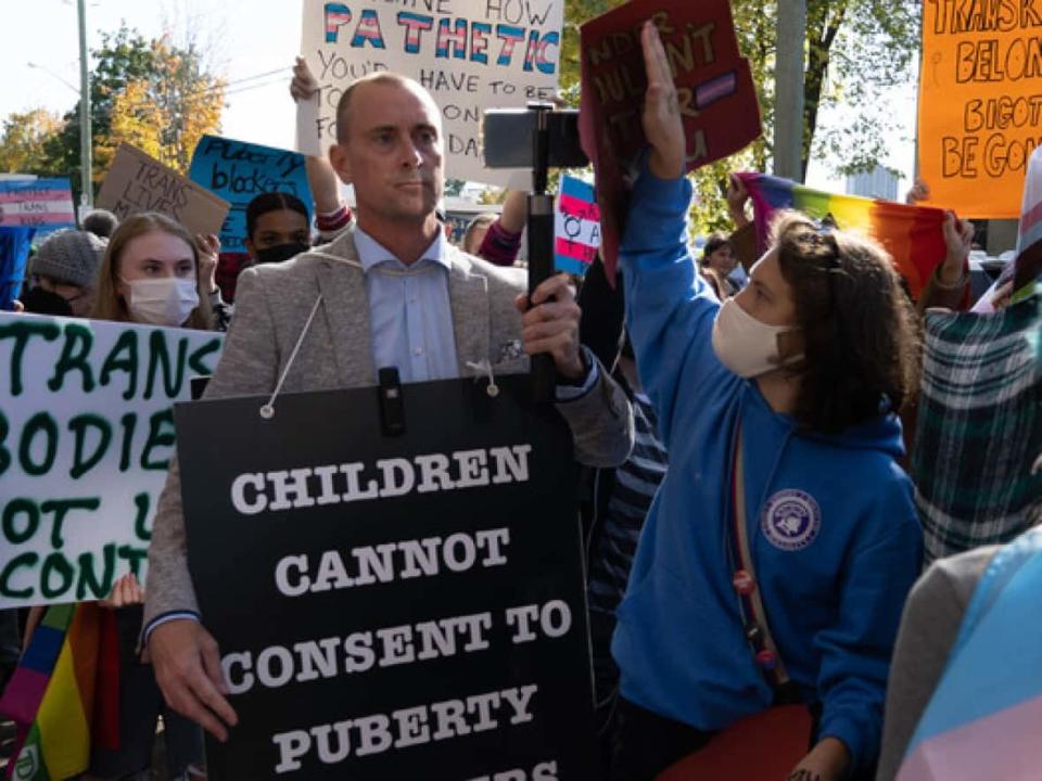 Chris Elston, center, is surrounded by counter-protesters in front of Broadview Public School in Ottaawa Tuesday. (Jean Delisle/CBC - image credit)