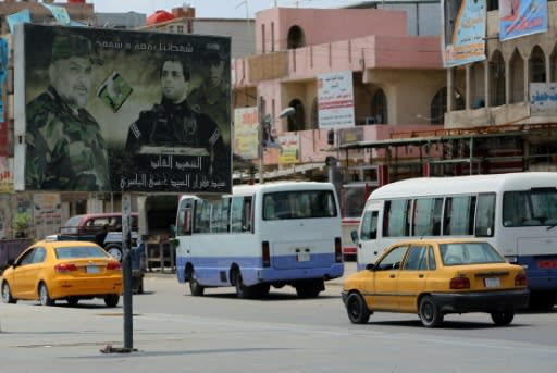 Traffic and an election poster on a road in Sadr City, the impoverished stronghold in northeast Baghdad of Iraqi cleric Moqtada Sadr