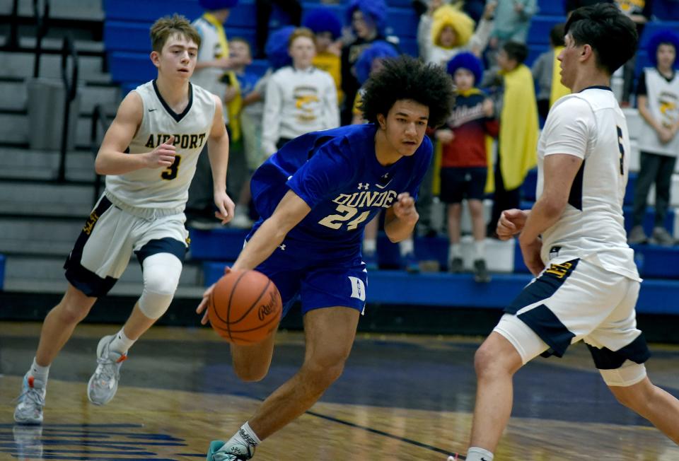 Braiden Whitaker of Dundee drives with pressure from Brandon McComas of Airport, trailing Brett Moore in the Division 2 District semifinals at Dundee High School Thursday.