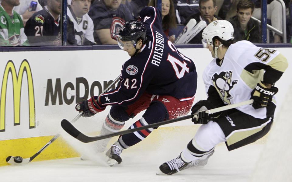 Columbus Blue Jackets' Artem Anisimov, left, of Russia, tries to clear the puck as Pittsburgh Penguins' Kris Letang defends during the second period of a first-round NHL playoff hockey game Monday, April 21, 2014, in Columbus, Ohio. (AP Photo/Jay LaPrete)