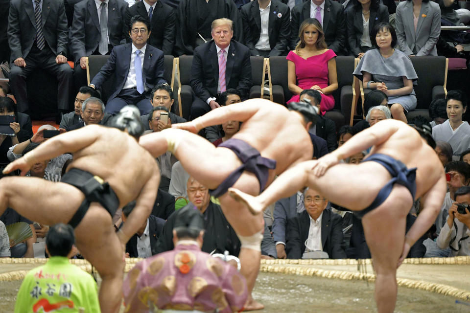 FILE - In this May 26, 2019, file photo, U.S. President Donald Trump, center back, and first lady Melania Trump, second right back, accompanied by Japanese Prime Minister Shinzo Abe, left, and his wife Akie Abe watch the ring-entering ceremony of sumo wrestlers during an annual summer sumo wrestling championship at the Ryogoku Kokugikan sumo arena in Tokyo. Sumo wrestling is going to get some extra attention because of the Tokyo Olympics. The Japan Sumo Association and local Olympic organizers are planning a sumo tournament on Aug. 12-13, just days after the Olympics end. (Kyodo News via AP)