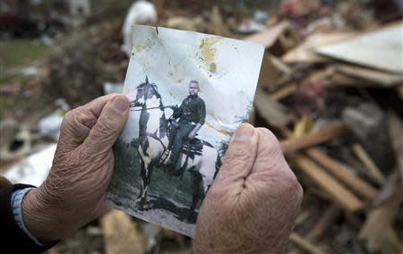 Darwin Henry holds up a treasured photo of himself as a young man riding a horse, that had been recovered from the debris that was his house in Mayflower, Arkansas April 29, 2014. REUTERS/Carlo Allegri