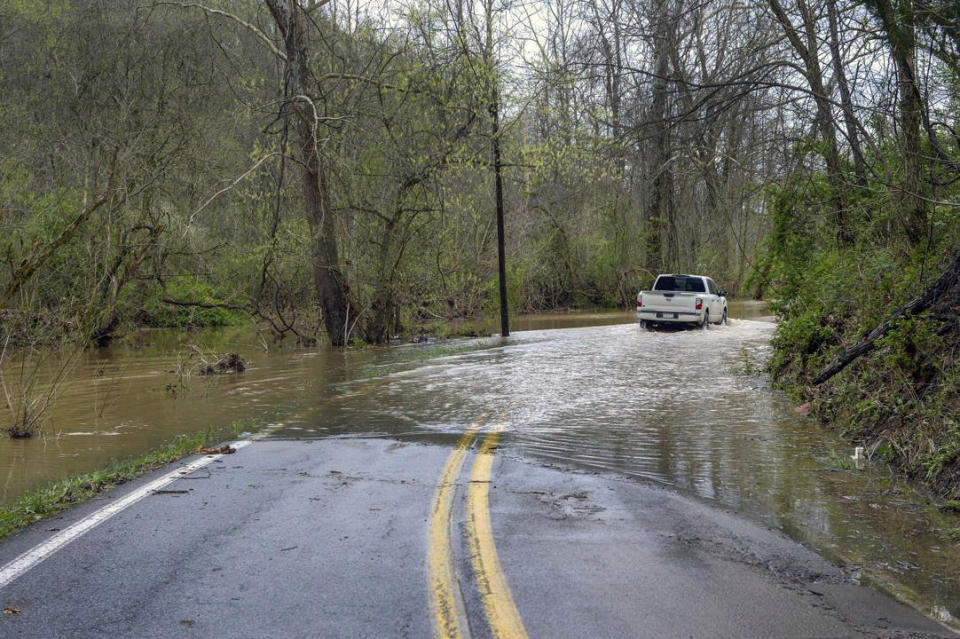 A pickup drives into flooded Smith Creek Road while heading toward Tornado, after record rainfall on Thursday in Kanawha County, on April 12, 2024. (Kenny Kemp/Charleston Gazette-Mail via AP)