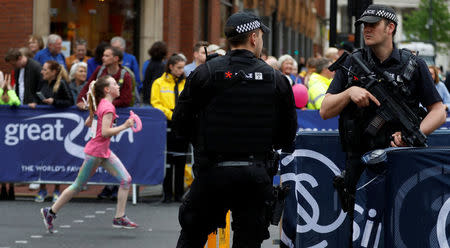 Armed police officers keep watch over junior runners competing in the Great Manchester Run in central Manchester, Britain May 28, 2017. REUTERS/Phil Noble