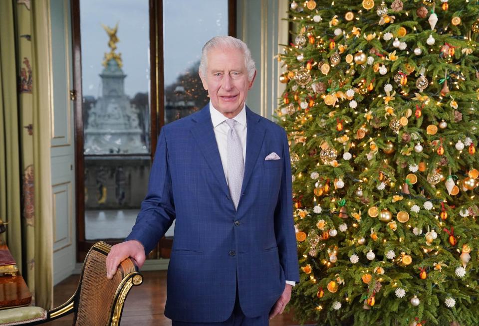 King Charles III gives his Christmas address in front of a Christmas tree at Buckingham Palace December 2023.