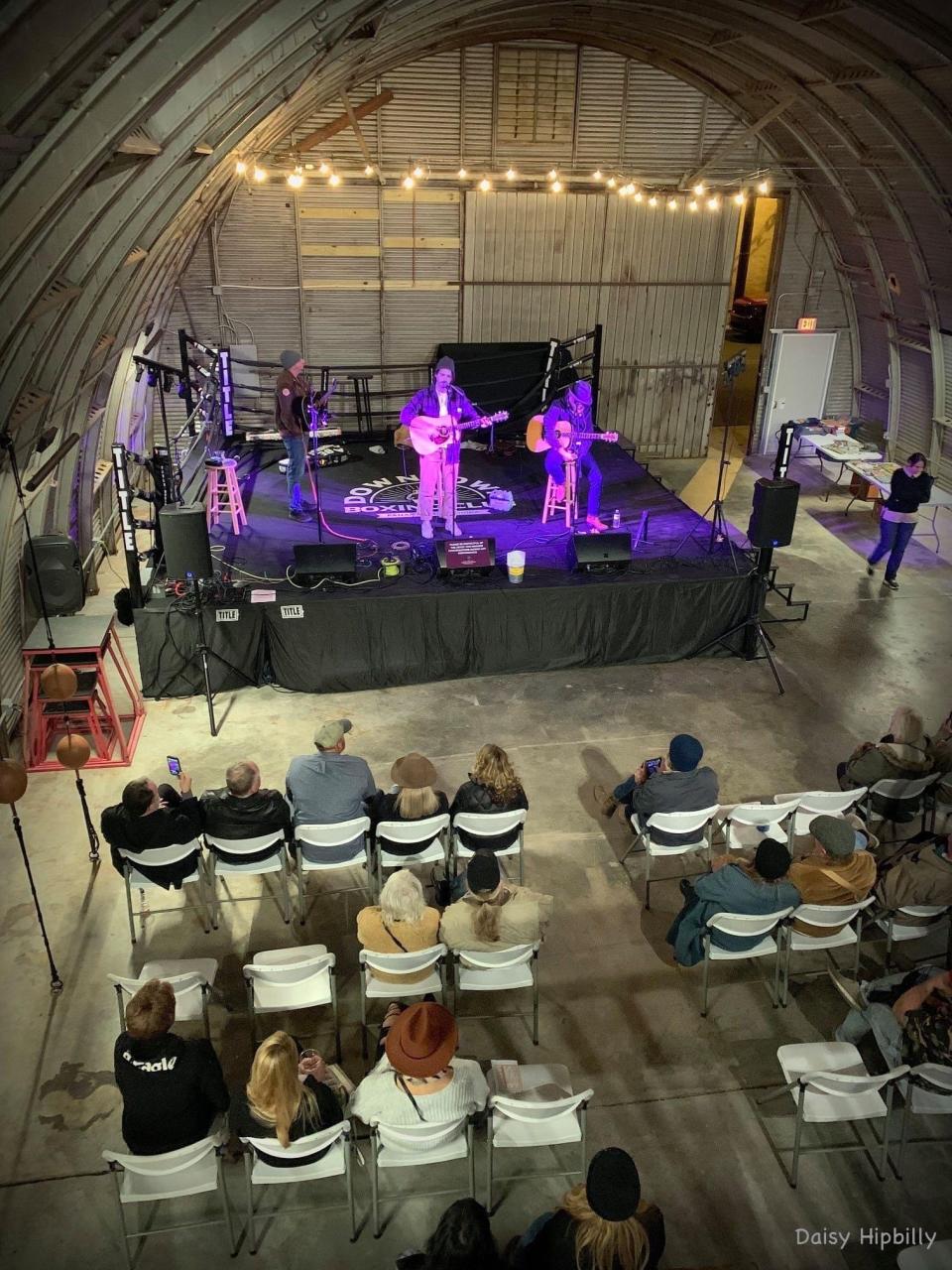 The crowd looks on as Abe Partridge, Nathan Evans Fox, and Shawn Byrne perform on stage at the Downtown Boxing Club during a previous Panama City Songwriters Festival.