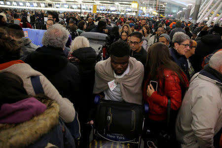 Large crowds try to make their way through the departures area of Terminal 4 at John F. Kennedy International Airport following a series of delayed and canceled flights and a water main break in New York City, U.S. January 7, 2018. REUTERS/Andrew Kelly