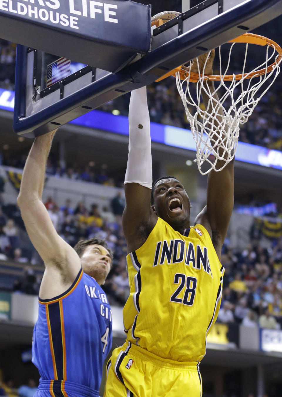 Indiana Pacers center Ian Mahinmi (28) gets a basket on a dunk in front of Oklahoma City Thunder forward Nick Collison in the second half of an NBA basketball game in Indianapolis, Sunday, April 13, 2014. The Pacers defeated the Thunder 102-97. (AP Photo/Michael Conroy)
