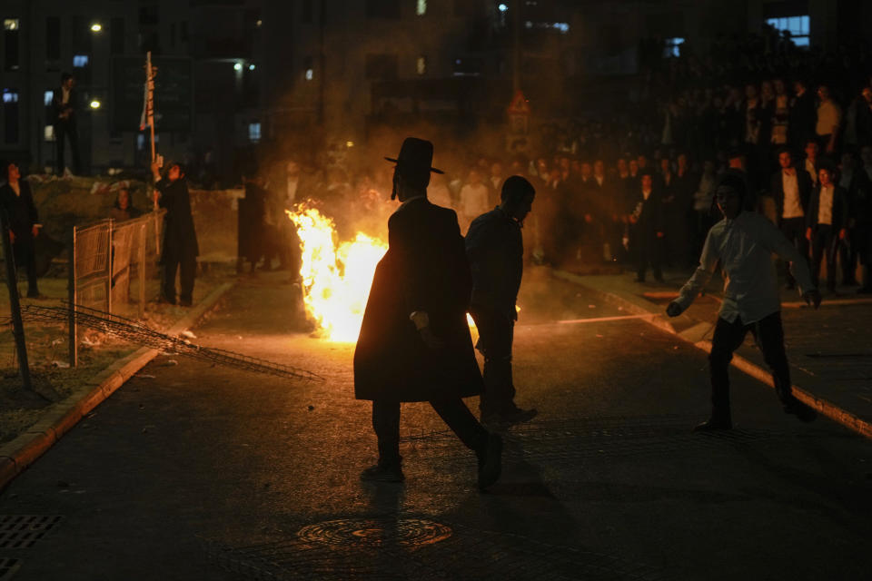 Ultra-Orthodox Jewish men burn trash during a protest against army recruitment in Jerusalem on Sunday, June 30, 2024. Israel's Supreme Court last week ordered the government to begin drafting ultra-Orthodox men into the army, a landmark ruling seeking to end a system that has allowed them to avoid enlistment into compulsory military service. (AP Photo/Ohad Zwigenberg)