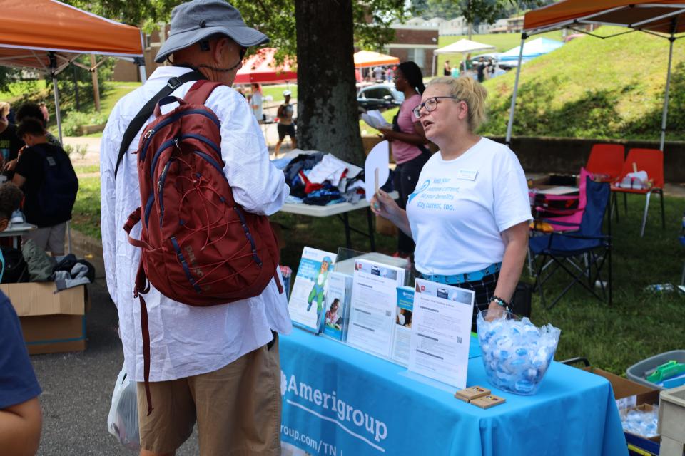 Patricia Cox, Amerigroup’s community relations representative, chats with a resident at the Western Heights community’s back-to-school block party on Aug. 1, 2023.