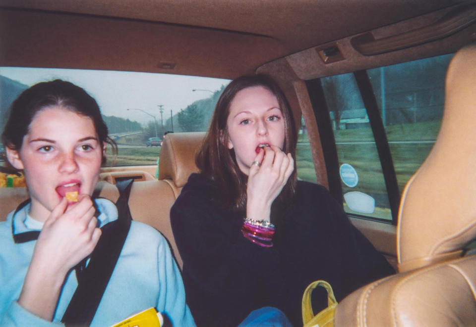 People in the back of a car eating snacks