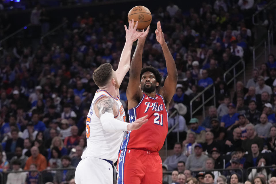 Philadelphia 76ers center Joel Embiid (21) shoots a 3-point basket over New York Knicks center Isaiah Hartenstein, left, during the first half in Game 1 of an NBA basketball first-round playoff series, Saturday, April 20, 2024, at Madison Square Garden in New York. (AP Photo/Mary Altaffer)