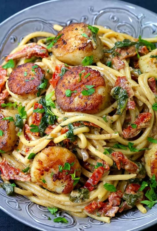 <p>Mantitlement</p><p>This recipe for creamy Tuscan spaghetti with jumbo scallops is one of our favorite ways to cook scallops! Skip the restaurant and make this seafood dinner right at home.</p><p><strong>Get the recipe: <a href="https://www.mantitlement.com/creamy-tuscan-spaghetti-with-jumbo-scallops/" rel="nofollow noopener" target="_blank" data-ylk="slk:Creamy Tuscan Spaghetti with Jumbo Scallops;elm:context_link;itc:0;sec:content-canvas" class="link rapid-noclick-resp">Creamy Tuscan Spaghetti with Jumbo Scallops</a></strong></p>