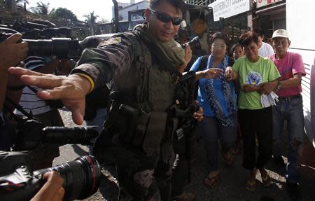 Residents taken as hostages and used as human shields by Muslim rebels of the Moro National Liberation Front (MNLF) during fighting with government soldiers are escorted by a soldier and a social worker (2nd L) after being released in Zamboanga city, in southern Philippines September 17, 2013. REUTERS/Erik De Castro