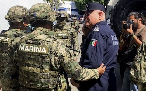 Mexican Navy members escort the Secretary of Public Security of Acapulco Max Lorenzo Sedano, right, after they took control of public security - Credit:  FRANCISCO ROBLES/AFP