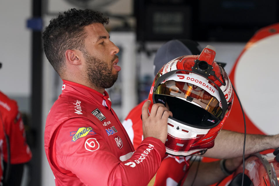 Bubba Wallace removes his helmet in his garage after a NASCAR Daytona 500 auto race practice session at Daytona International Speedway, Wednesday, Feb. 10, 2021, in Daytona Beach, Fla. Wallace turned the fastest time for the practice session. (AP Photo/John Raoux)