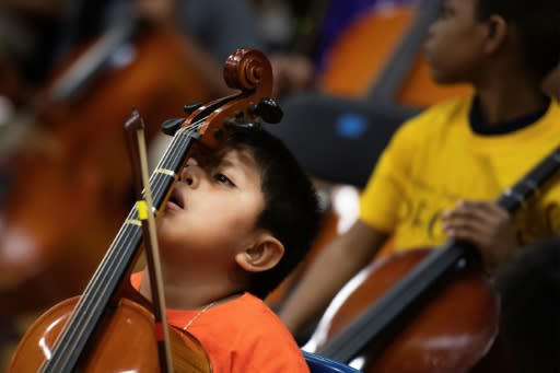 Oliver Cuellar rests his face on the neck of his cello during practice before the OrchKids String Fling concert at the Lockerman Bundy Elementary School in Baltimore