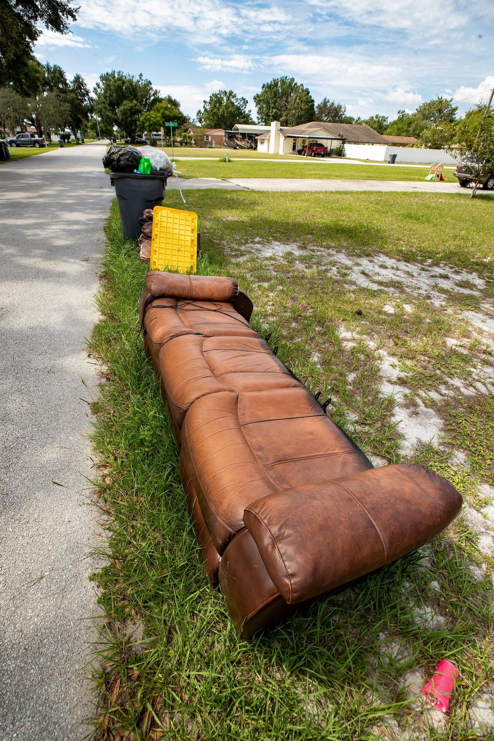 Garbage cans and old furniture can be seen along on Hurst Road in Auburndale.