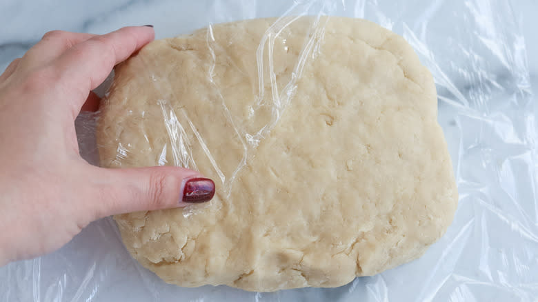 dough covered with plastic wrap