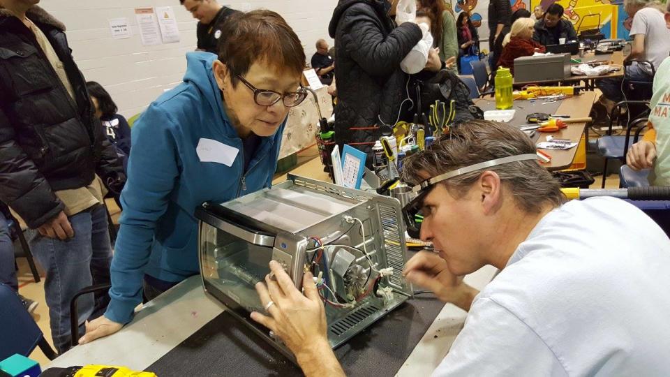 A woman looks on while her toaster oven undergoes repairs at a Toronto Repair Cafe event. (Toronto Repair Cafe/Facebook)