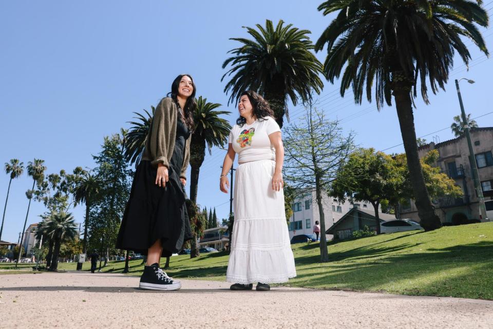 Two women standing in a park.