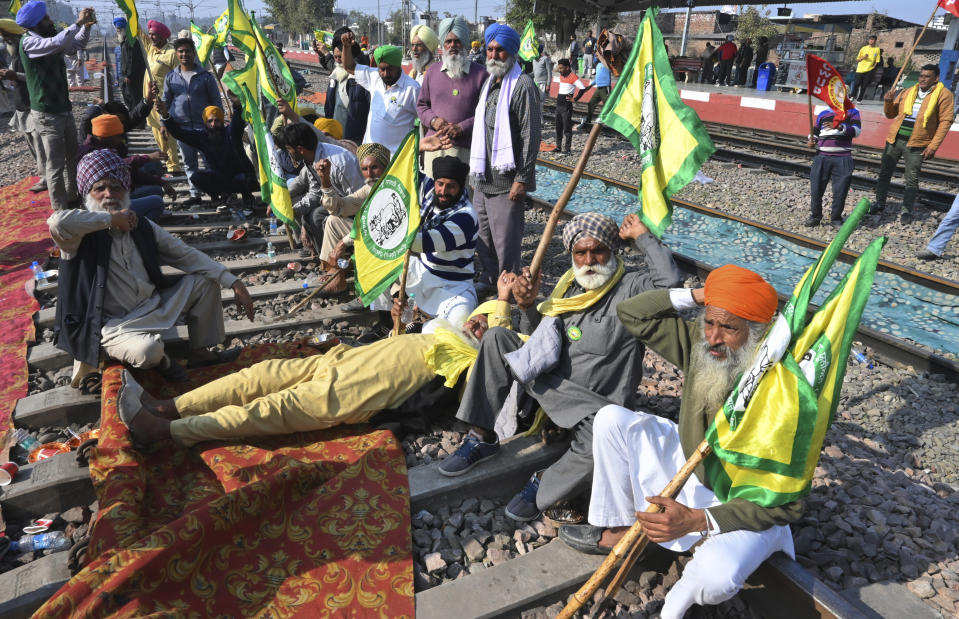 Protesting farmers demanding guaranteed crop prices for their produce sit on train tracks at a railway station in Rajpura, India, Thursday, Feb.15, 2024. Some farmer and trade unions have announced a countrywide rural strike on Friday. (AP Photo/Rajesh Sachar)