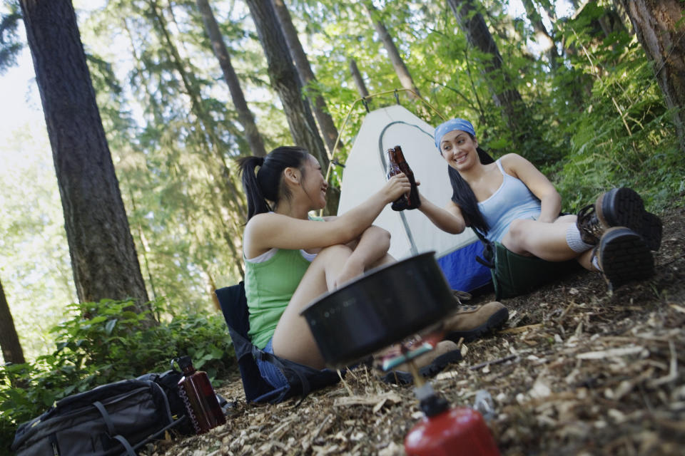 two women camping enjoying beer