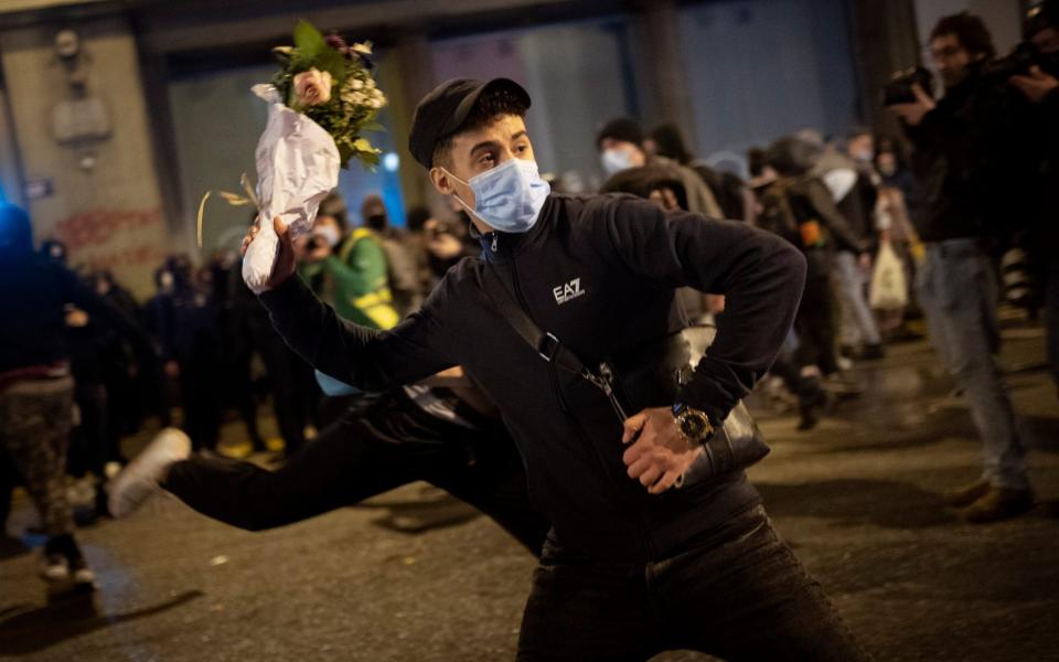 The pose was similar to that of Banksy image Love Is In The Air, Flower Thrower. CREDIT: AP   - Emilio Morenatti /AP