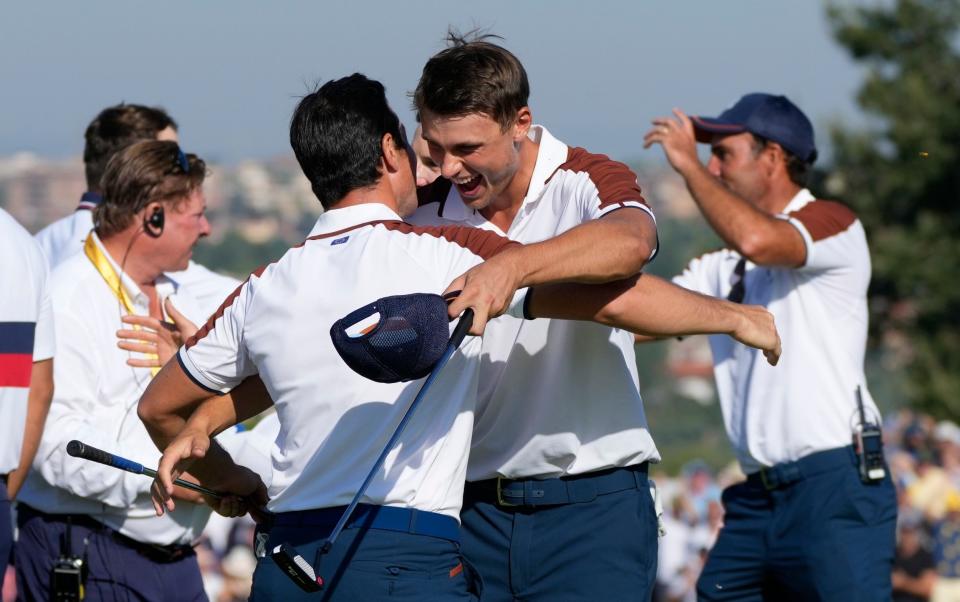 Europe's Viktor Hovland, left and Europe's Ludvig Aberg hug on the 11th green after defeating the United States pair of Scottie Scheffler and Brooks Koepka