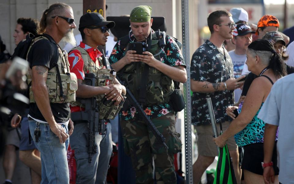 Members of the boogaloo movement watch a demonstration near the BOK Center where President Trump will hold a campaign rally in Tulsa, Okla., Saturday, June 20, 2020 - Charlie Riedel/AP