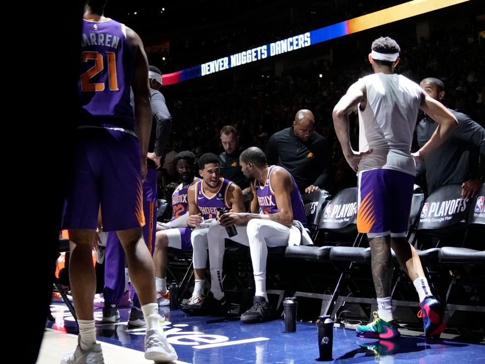 Phoenix Suns guard Devin Booker (1) and Phoenix Suns forward Kevin Durant (35) talk during a timeout during the second quarter of the Western Conference semifinals at Ball Arena in Denver on May 9, 2023.