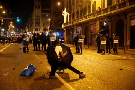 Riot police stand guard during a protest after a verdict in a trial over a banned independence referendum, in Barcelona