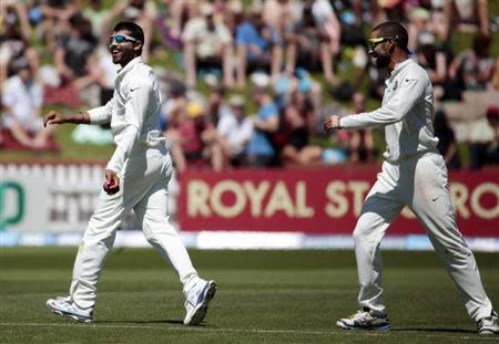 Ravindra Jadeja (L) and Shikhar Dhawan celebrate taking the wicket of New Zealand's Corey Anderson during the second innings on day three of the second international test cricket match at the Basin Reserve in Wellington, February 16, 2014. REUTERS/Anthony Phelps