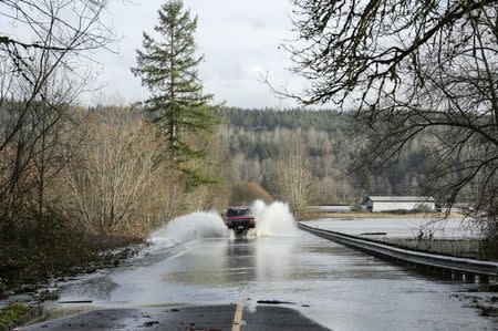 A truck drives through flood waters of the Snoqualmie River on NE Carnation Farm Road during a storm in Carnation, Washington December 9, 2015. REUTERS/Jason Redmond