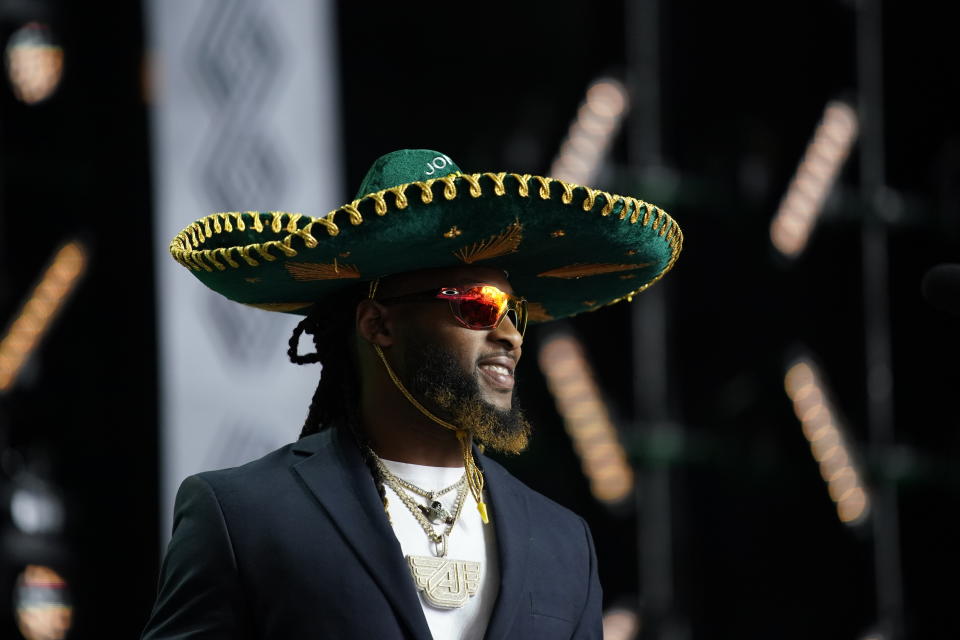 Green Bay Packers' Aaron Jones walks on the stage to announce North Dakota State wide receiver Christian Watson as the team's pick during the second round of the NFL football draft Friday, April 29, 2022, in Las Vegas. (AP Photo/John Locher)