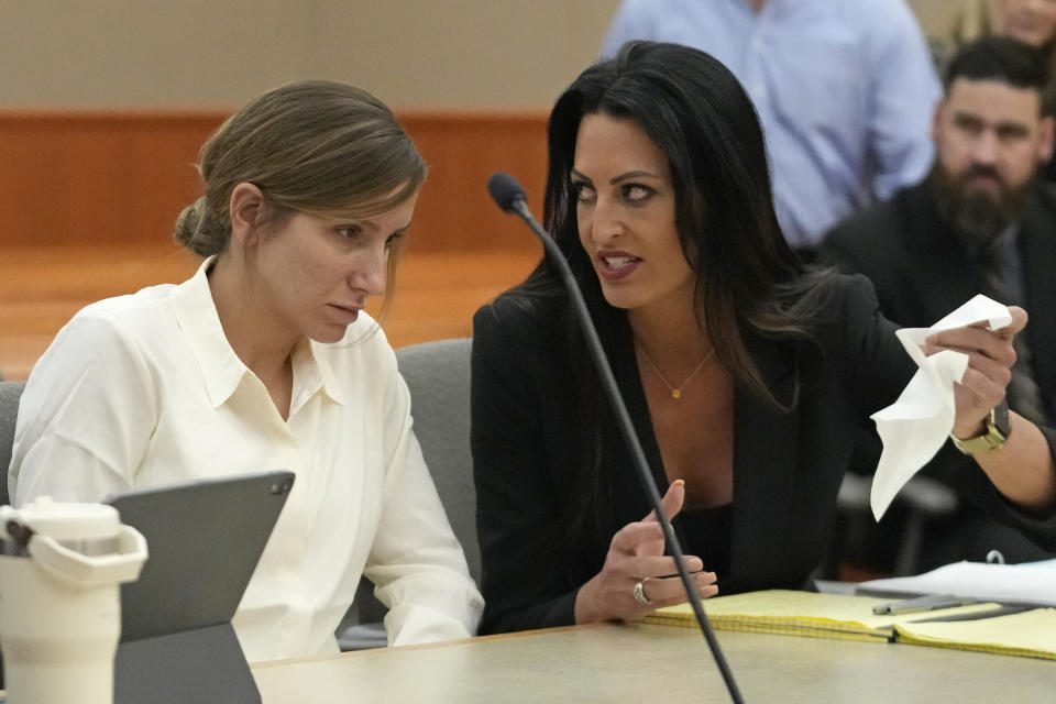 Kouri Richins, a Utah mother of three who authorities say fatally poisoned her husband then wrote a children's book about grieving, speaks with her attorney Skye Lazaro during a bail hearing Monday, June 12, 2023, in Park City, Utah. A judge ruled to keep her in custody for the duration of her trial. (AP Photo/Rick Bowmer, Pool)