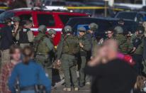 Arapahoe police gather at parking lots across from Arapahoe High School, after a student opened fire in the school in Centennial, Colorado December 13, 2013. The student seeking to confront one of his teachers opened fire at the Colorado high school on Friday, wounding at least two classmates before apparently taking his own life, law enforcement officials said. REUTERS/Evan Semon (UNITED STATES - Tags: EDUCATION CRIME LAW)