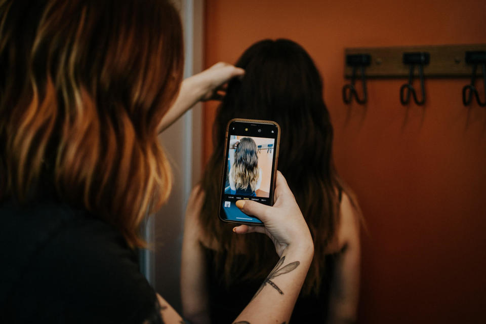 Alexis taking a photo of their hair