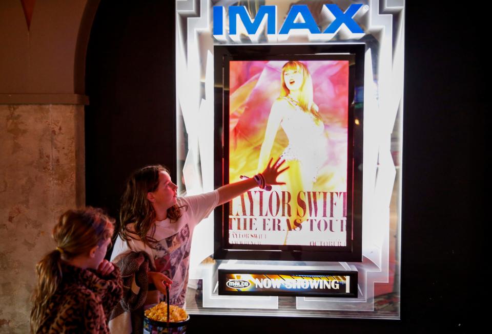 Auri Smith, 10, looks at the poster for “Taylor Swift: The Eras Tour” as Olivia Cassidy, 10, touches it before they go in to watch the movie at Malco Paradiso Cinema Grill and IMAX in Memphis, Tenn., on Saturday, October 14, 2023.