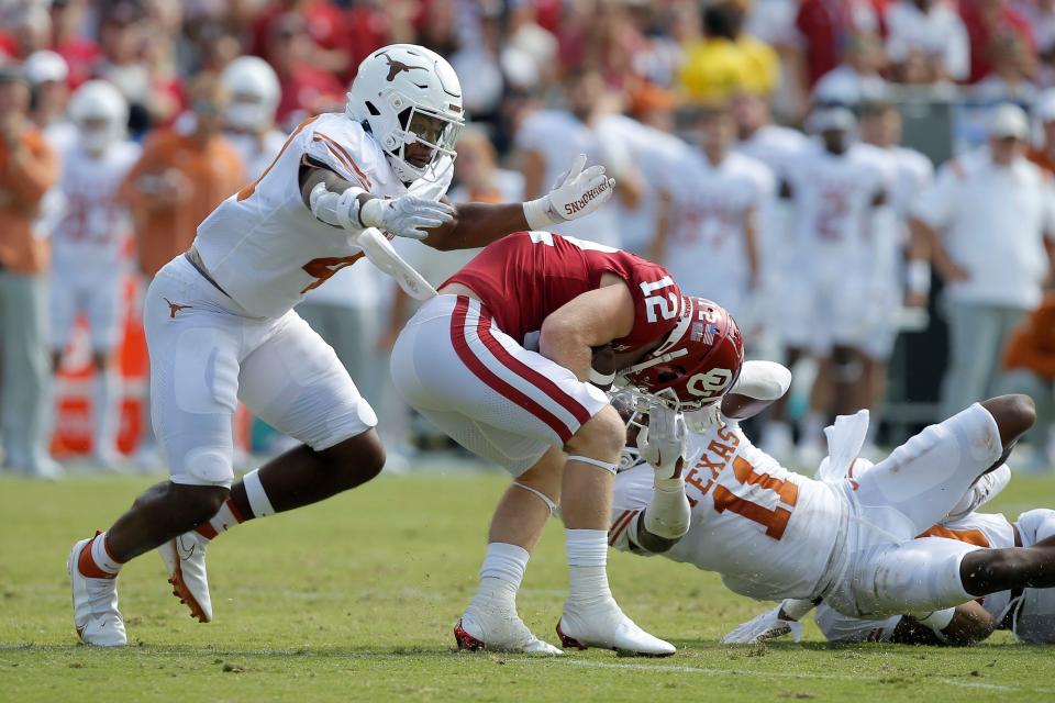 Oklahoma Sooners wide receiver Drake Stoops (12) is brought down by Texas Longhorns defensive back Austin Jordan (4) and Texas Longhorns defensive back Anthony Cook (11) during the Red River Showdown college football game between the University of Oklahoma (OU) and Texas at the Cotton Bowl in Dallas, Saturday, Oct. 8, 2022. 