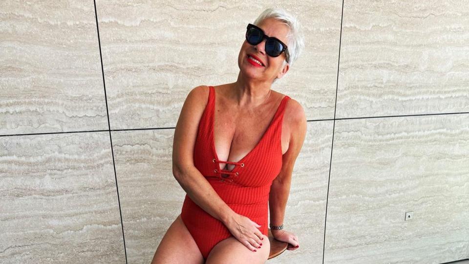 Denise Welch smiling in an orange swimsuit 