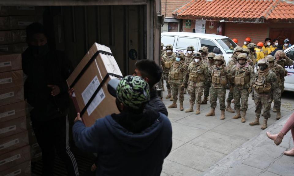 Employees of the electoral court, guarded by the military police, load a truck with electoral material to be distributed for Sunday’s general election, in La Paz, on Firday.