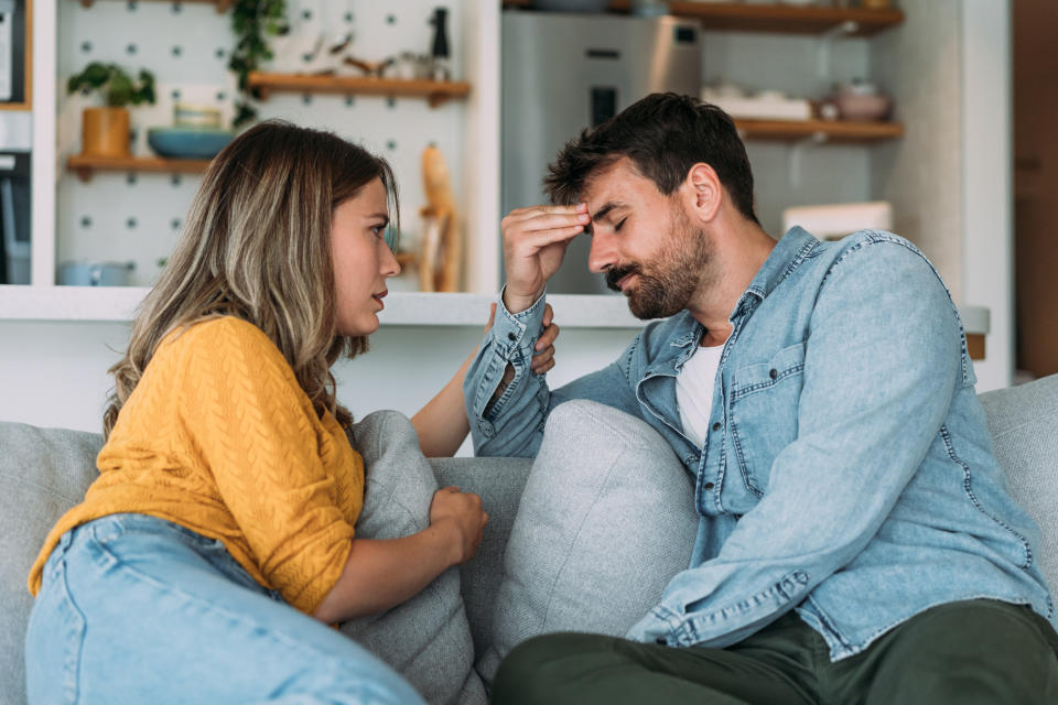 Shot of young wife expressing empathy and compassion to her sad frustrated husband. (Getty)