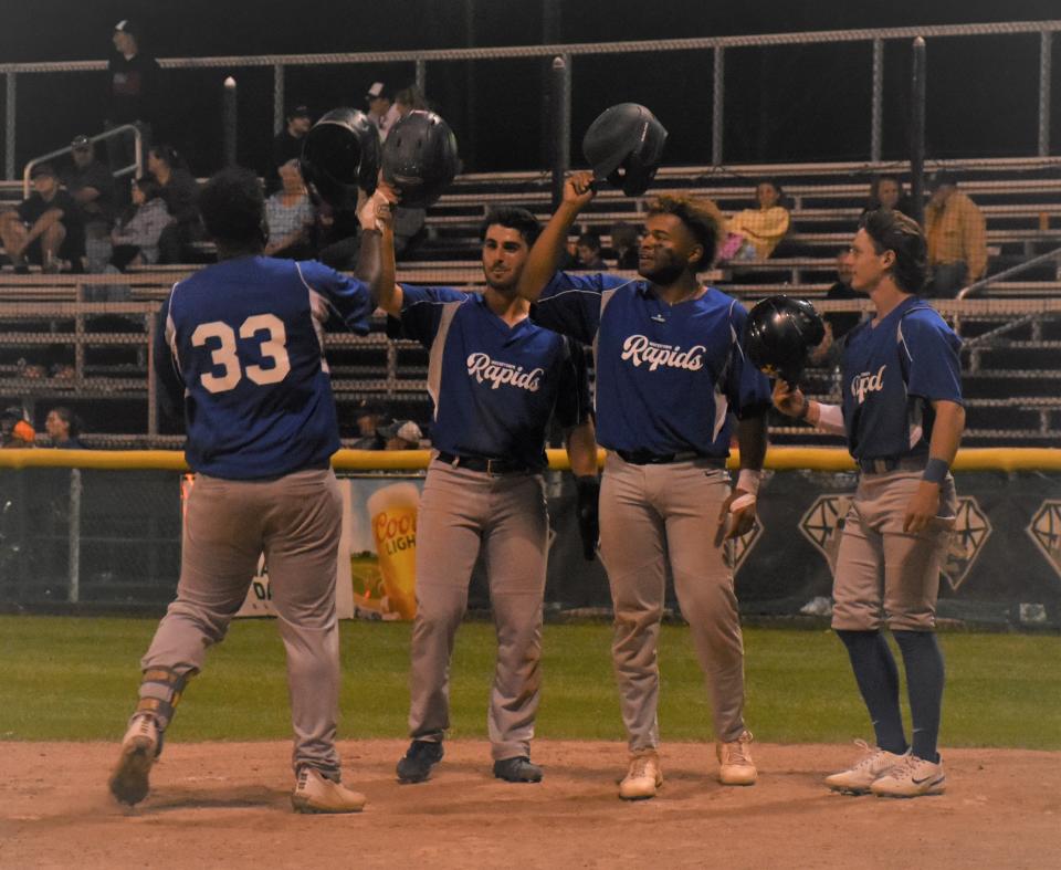 Watertown players greet Rapids teammate Tyree Bradley (33) at home plate after his second grand slam Friday against the Mohawk Valley DiamondDawgs at Veterans Memorial Park.