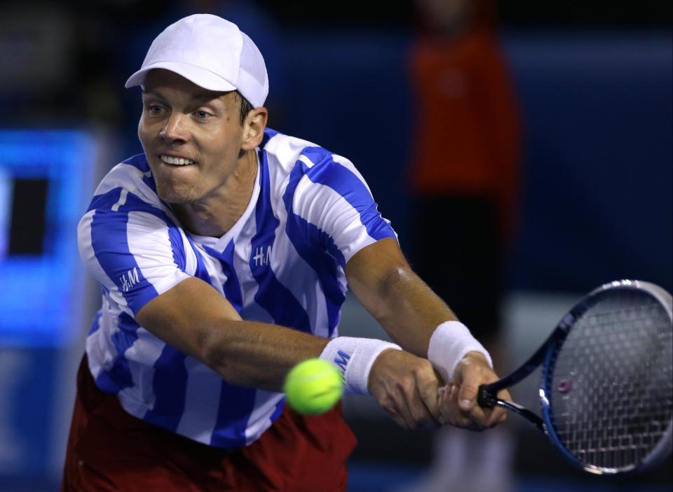 Tomas Berdych of the Czech Republic makes a backhand return to Stanislas Wawrinka of Switzerland during their semifinal at the Australian Open tennis championship in Melbourne, Australia, Thursday, Jan. 23, 2014.(AP Photo/Aaron Favila)