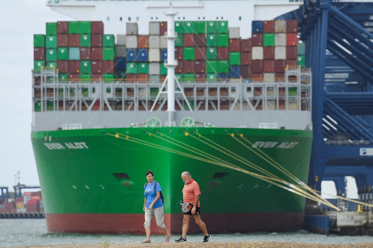 People walk nearby a container ship at UK's biggest container port Felixstowe, as workers begin an 8-day strike, in Felixstowe, Britain, August 21, 2022. REUTERS/Toby Melville